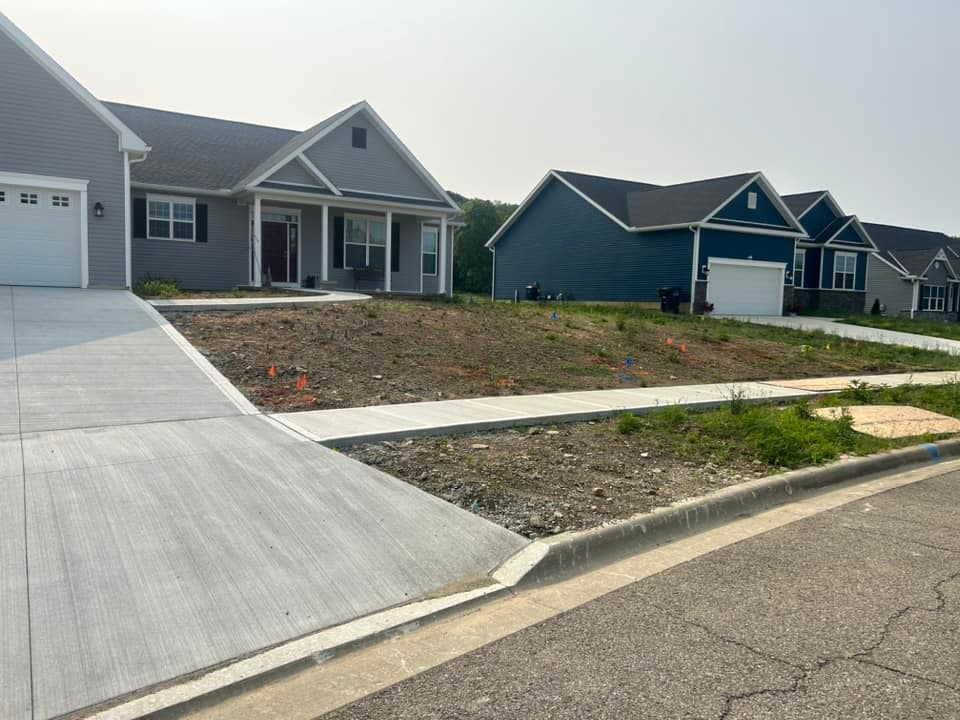 Newly built residential area with a house and an empty lot ready for development.